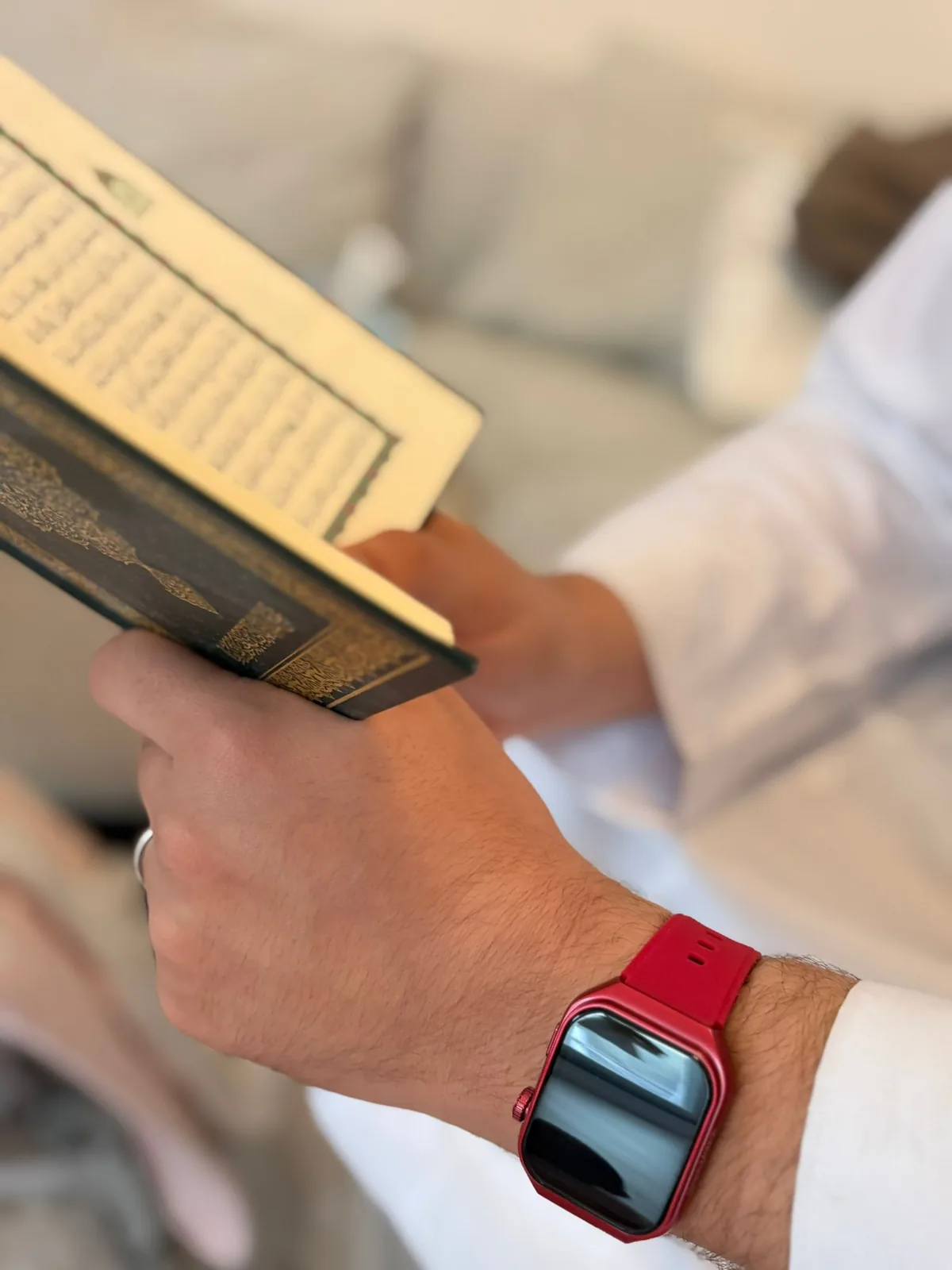 Red M² Watch held with the Quran